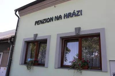 a white building with windows and a sign on it at Penzion Na Hrazi in Poděbrady