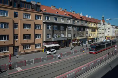 a red bus driving down a street next to buildings at Cozy Apartments with Terrace near Prague Castle in Prague