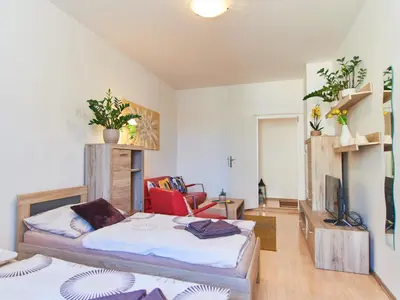 a bedroom with a bed and a chair in it at Cozy Apartments with Terrace near Prague Castle in Prague