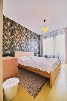 a bedroom with a bed and a large window at Hostel Prazacka in Prague