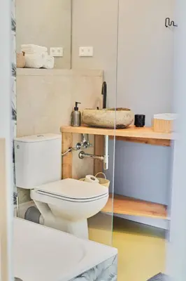 a bathroom with a toilet and a shelf with towels at Hostel Prazacka in Prague