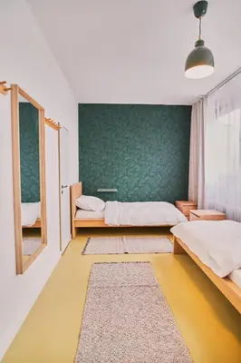 a bedroom with two beds and a green wall at Hostel Prazacka in Prague