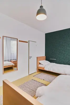 a bedroom with two beds and a mirror at Hostel Prazacka in Prague