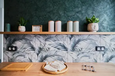 a dining room with a wall with a floral wallpaper at Hostel Prazacka in Prague