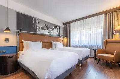 a hotel room with two beds and a chair at Radisson Blu Hotel Prague in Prague