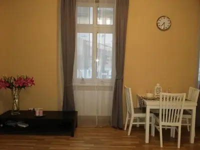 a dining room with a table and a clock on a window at NOT POSSIBLE TO BOOK !!! Apartment Vltavska B in Prague