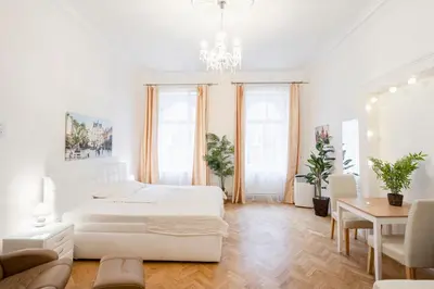 a white bedroom with two beds and a table at Prague Palace - Wenceslas Square in Prague