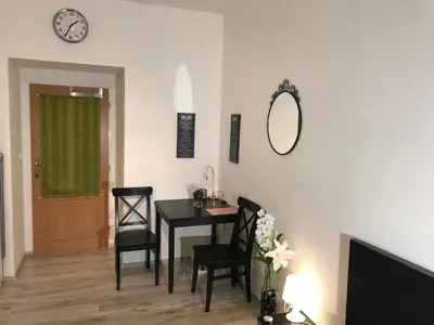 a dining room with a table and chairs and a clock at Big Homebase with Billardtable in Prague