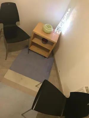 a black chair and a table with a bowl on it at Big Homebase with Billardtable in Prague