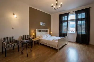 a bedroom with a bed and a chair and a window at Royal Road Residence in Prague