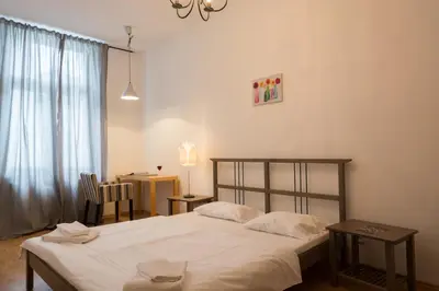 a bedroom with a bed and a table and a window at Royal Road Residence in Prague
