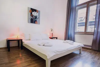 a white bed in a room with a window at Royal Road Residence in Prague