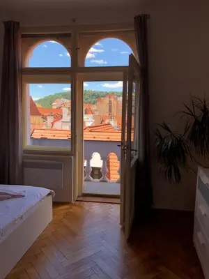 a bedroom with a large window with a view of a city at Royal Road Residence in Prague