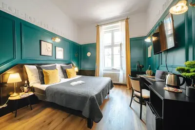 a living room with a blue couch and a flat screen tv at Hotel Praga 1885 by Wagnerstays in Prague