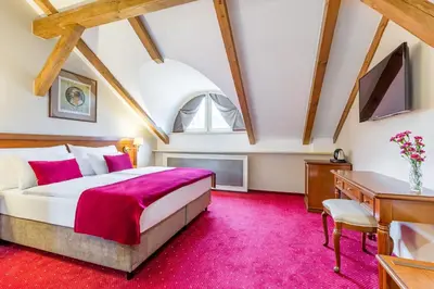 a bedroom with a large bed and a desk at Hotel Caruso Old Town in Prague
