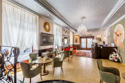 a living room with chairs and tables and a living room at Hotel Caruso Old Town in Prague