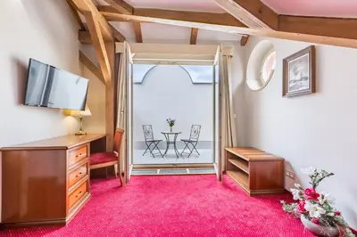 a room with a television and a table with chairs at Hotel Caruso Old Town in Prague