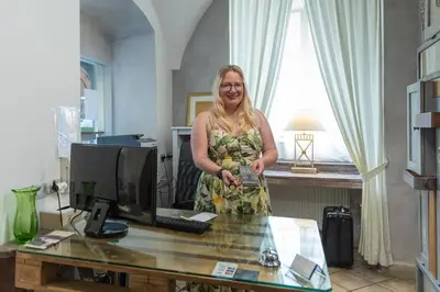 a woman standing in front of a desk with a computer at Miss Sophie's Charles Bridge in Prague