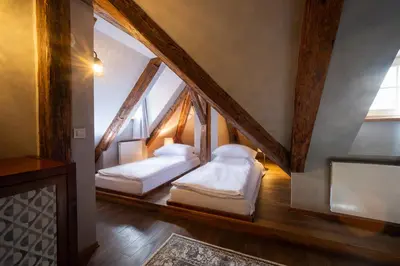 two beds in a room with a staircase at Miss Sophie's Charles Bridge in Prague