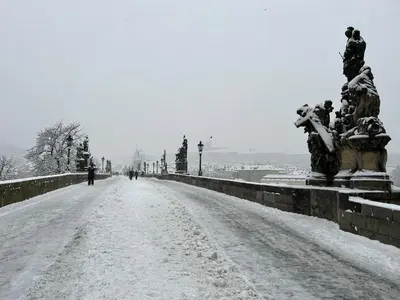 a snow covered bridge with a person walking down a street at Hostel Downtown in Prague