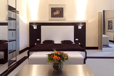 a bedroom with a bed and a vase of flowers on a table at Old Town Square Residence by Emblem in Prague