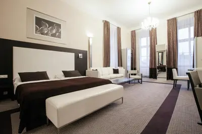 a bedroom with a large bed and a living room at Old Town Square Residence by Emblem in Prague
