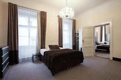 a bedroom with a bed and a chandelier at Old Town Square Residence by Emblem in Prague