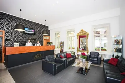a lobby with a bar with two men standing at a counter at Deminka Palace in Prague