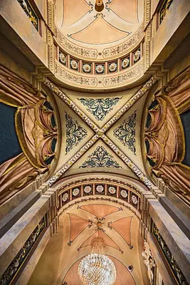 an ornate ceiling in a building with a chandelier at Deminka Palace in Prague