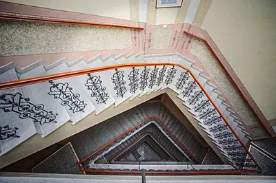 an overhead view of a spiral staircase withcriptions on it at Deminka Palace in Prague