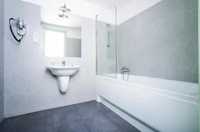 a white bathroom with a sink and a shower at Deminka Palace in Prague