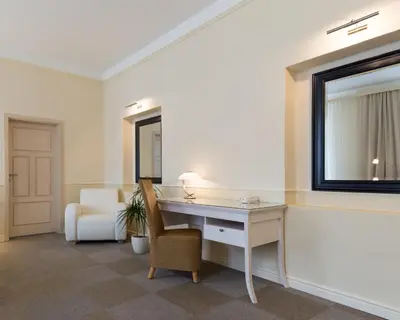 a room with a desk and a chair and a mirror at Unitas Hotel in Prague