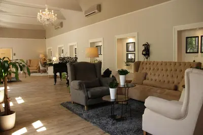 a living room with a couch and chairs and a piano at Unitas Hotel in Prague