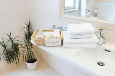 a bathroom with a basket of towels on a sink at Unitas Hotel in Prague