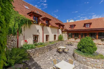 a courtyard of a house with tables and chairs at Hotel BELLA in Prague