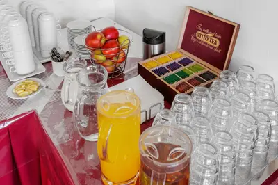 a table topped with glasses and a box of drinks at Hotel BELLA in Prague