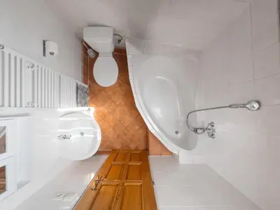 a bathroom with a tub and a sink and a toilet at Hotel BELLA in Prague