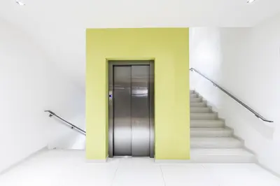 a hallway with a door and stairs in a building at Hotel Herrmes in Prague