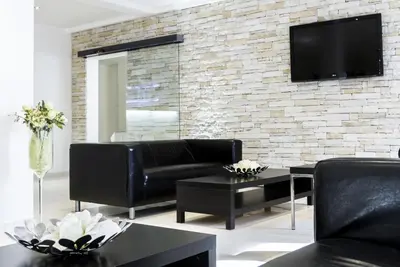 a living room with a couch and a tv on a brick wall at Hotel Herrmes in Prague