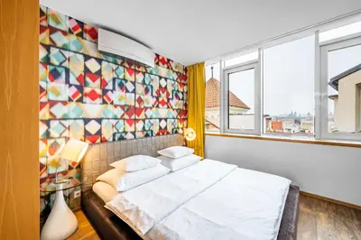 a bedroom with a bed and a tiled wall at Malostranská Residence in Prague