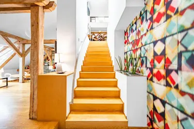 a staircase in a house with a mosaic wall at Malostranská Residence in Prague
