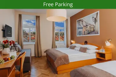 a hotel room with a bed and two windows at Hotel Merkur - Czech Leading Hotels in Prague