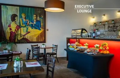 a restaurant with a bar and a table with food at Hotel Merkur - Czech Leading Hotels in Prague