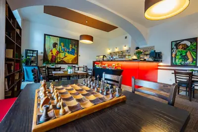 a room with a chessboard on a table with chairs at Hotel Merkur - Czech Leading Hotels in Prague