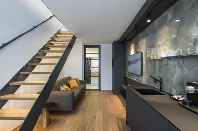 a living room with a staircase and a couch at Fully renovated stylish duplex in a convenient location in Prague