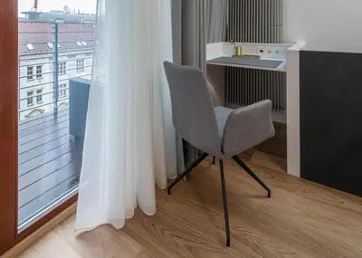 a chair in a room with a window at Fully renovated stylish duplex in a convenient location in Prague