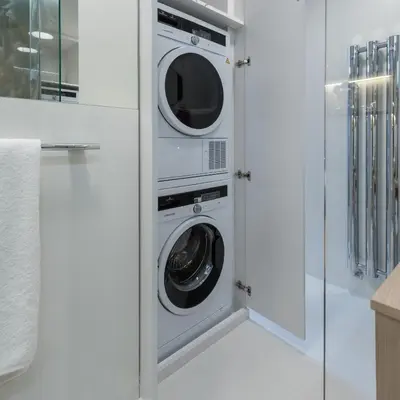 a white laundry room with two washer and dryer at Fully renovated stylish duplex in a convenient location in Prague
