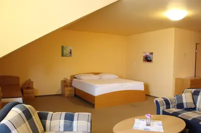 a hotel room with a bed and two chairs at Motel U Krbu in Vestec