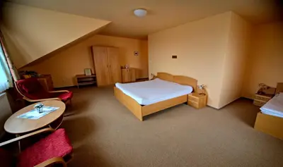 a bedroom with a bed and a table and chairs at Motel U Krbu in Vestec