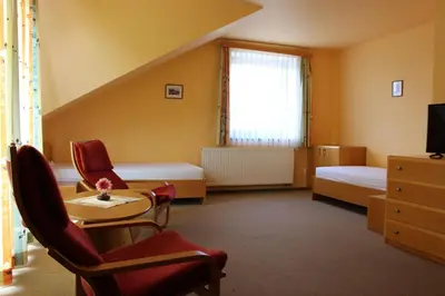 a room with two beds and a table and chairs at Motel U Krbu in Vestec